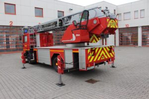 Feuerwehr Leiterwagen mit Drehleiter in Rhein-Neckar, geeignet für Brand- und Rettungseinsätze, modern ausgestattet, vor einer Feuerwache parkend.